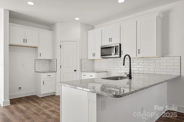 a kitchen with granite countertop a sink a stove and refrigerator