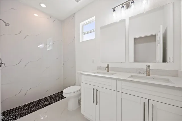 a bathroom with a sink a toilet and a mirror