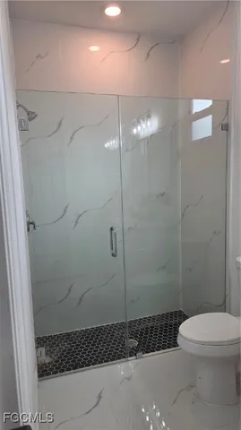a bathroom with a shower a toilet and sink