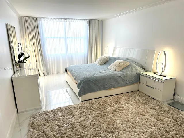 a bedroom with a bed and a chair with the wooden floor