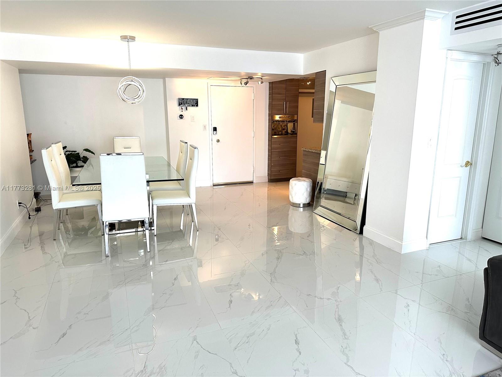 427 Golden Isles Drive, Unit 5G Hallandale Beach, FL 33009 - Photo 2 of 35 a living room with furniture and a wooden floor