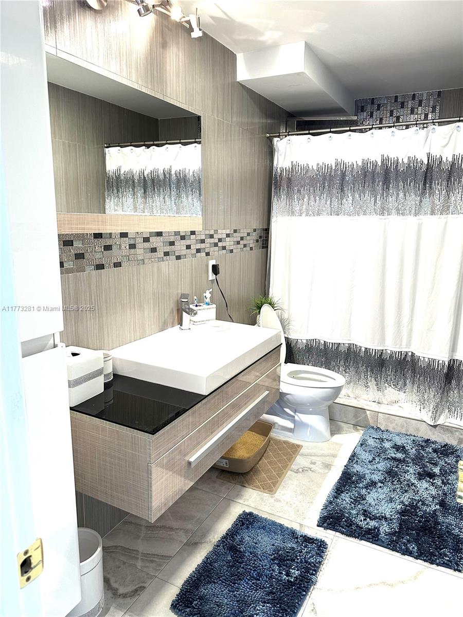 427 Golden Isles Drive, Unit 5G Hallandale Beach, FL 33009 - Photo 21 of 35 a bathroom with a sink and a mirror