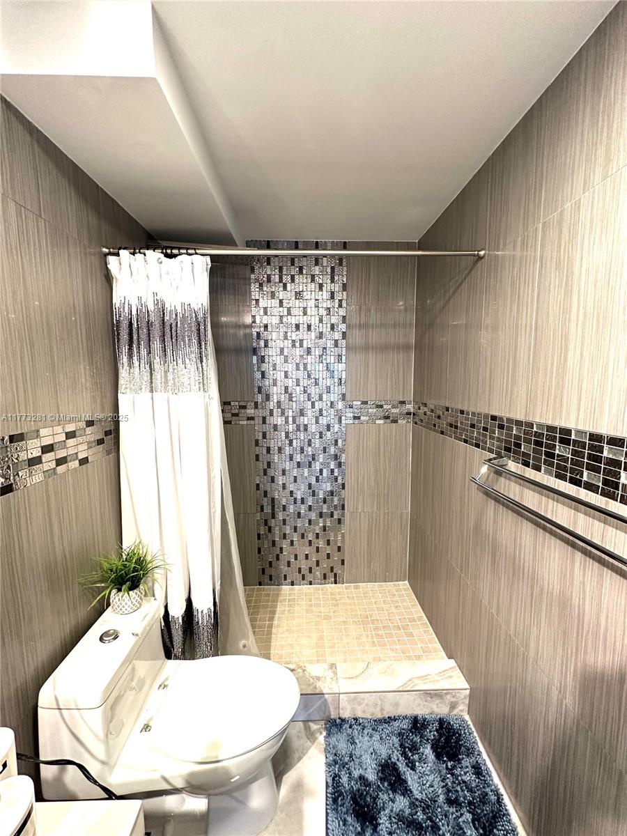 427 Golden Isles Drive, Unit 5G Hallandale Beach, FL 33009 - Photo 23 of 35 a bathroom with a bathtub and shower