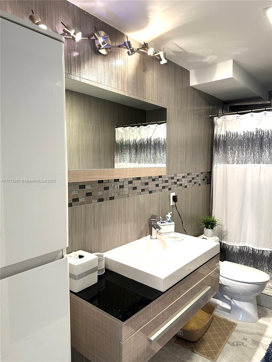 427 Golden Isles Drive, Unit 5G Hallandale Beach, FL 33009 - Photo 24 of 35 a bathroom with a sink and mirror