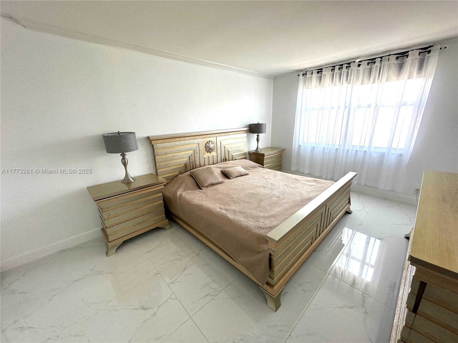 427 Golden Isles Drive, Unit 5G Hallandale Beach, FL 33009 - Photo 25 of 35 a bedroom with a bed and window