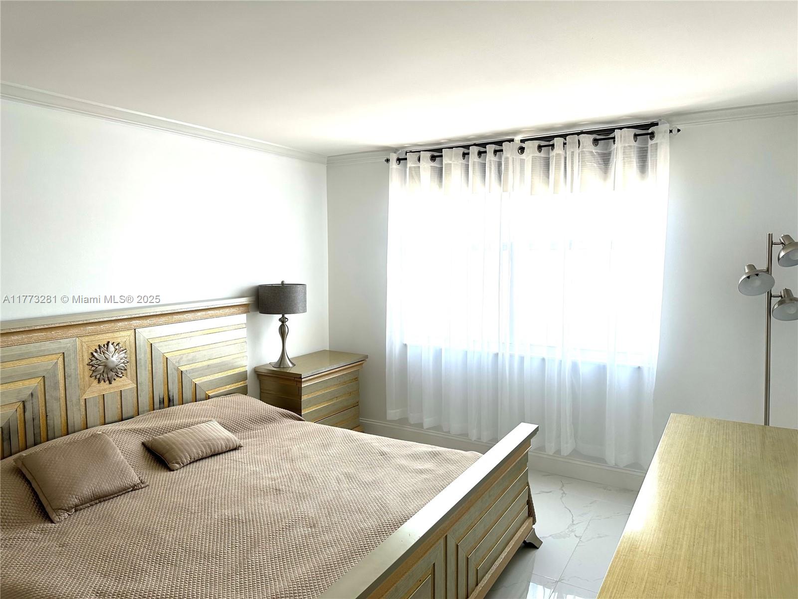 427 Golden Isles Drive, Unit 5G Hallandale Beach, FL 33009 - Photo 26 of 35 a bedroom with furniture and a window