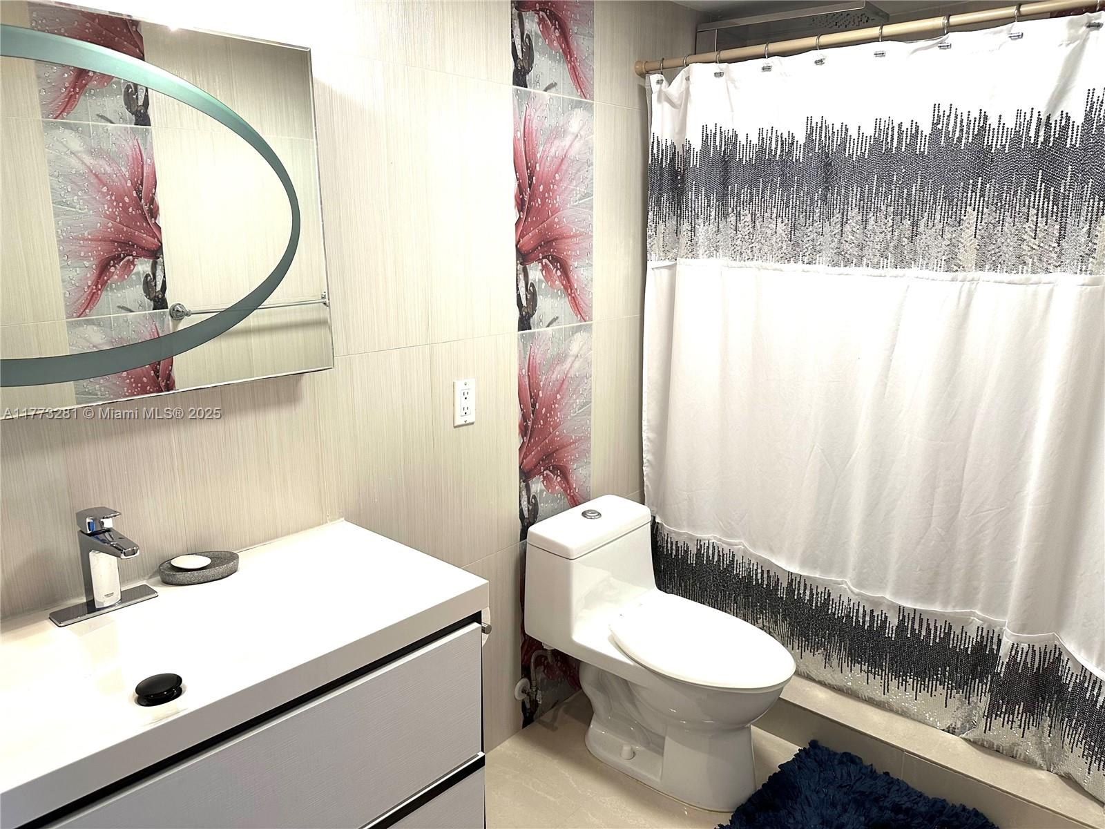 427 Golden Isles Drive, Unit 5G Hallandale Beach, FL 33009 - Photo 29 of 35 a bathroom with a sink a toilet and a mirror