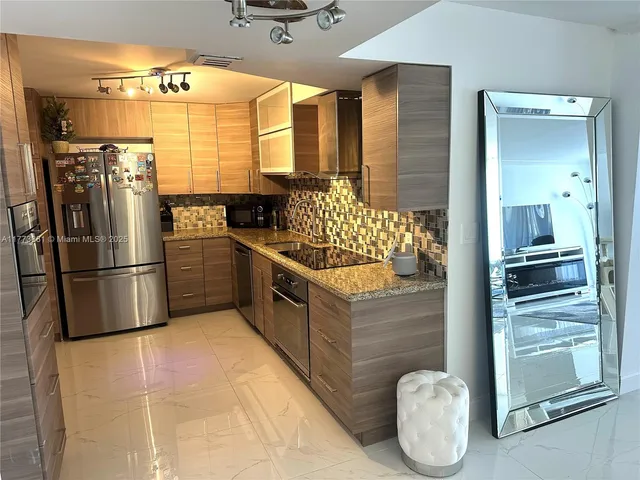 a kitchen with granite countertop a refrigerator and a stove