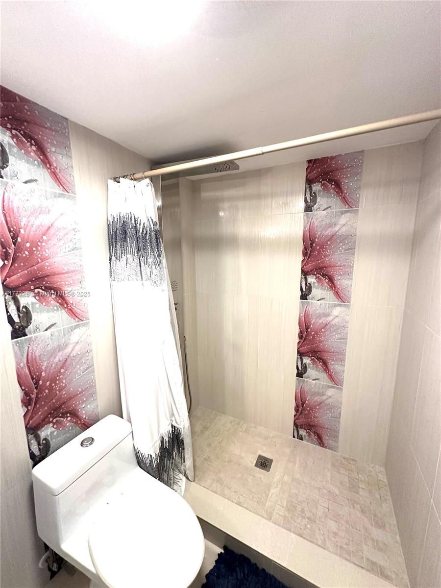 427 Golden Isles Drive, Unit 5G Hallandale Beach, FL 33009 - Photo 31 of 35 a bathroom with a sink toilet and shower