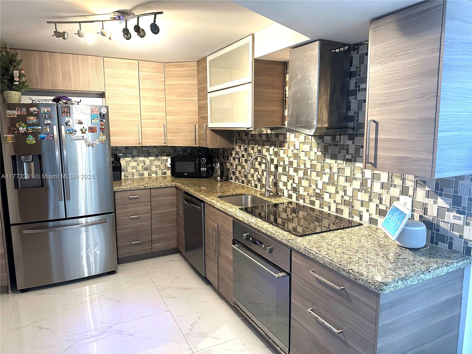 427 Golden Isles Drive, Unit 5G Hallandale Beach, FL 33009 - Photo 4 of 35 a kitchen with stainless steel appliances granite countertop a sink stove and refrigerator