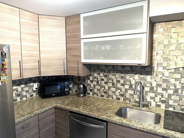a kitchen with a sink a counter top space and a large window