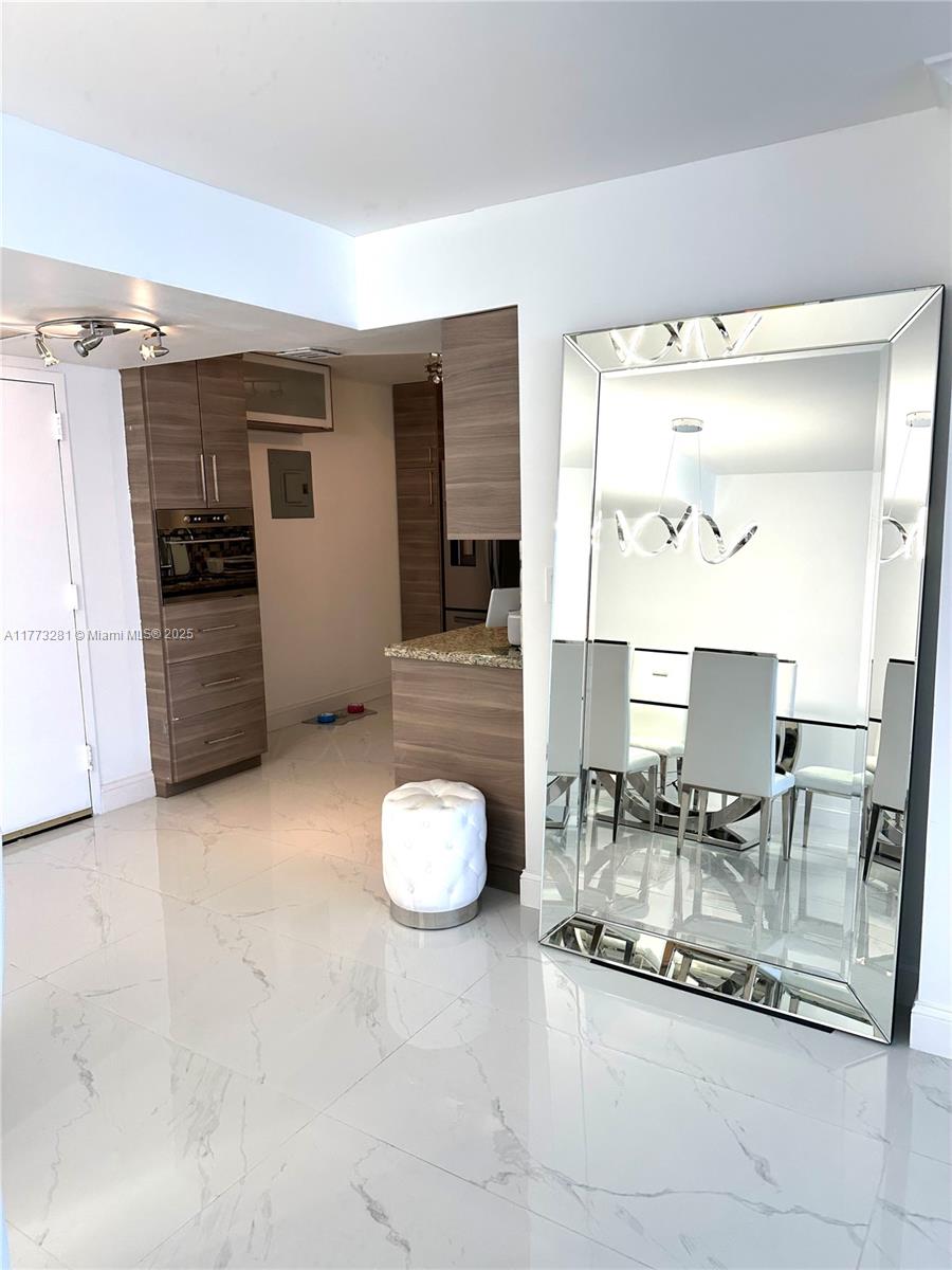 427 Golden Isles Drive, Unit 5G Hallandale Beach, FL 33009 - Photo 7 of 35 a room with furniture and a flat screen tv