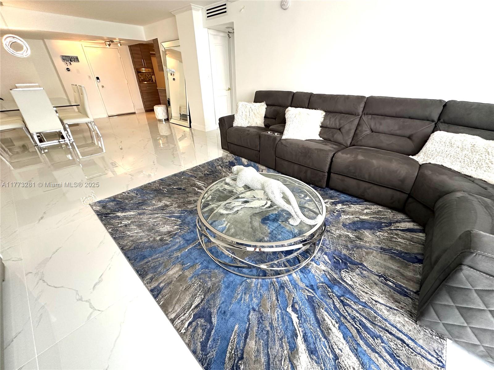 427 Golden Isles Drive, Unit 5G Hallandale Beach, FL 33009 - Photo 10 of 35 a living room with furniture and a large mirror