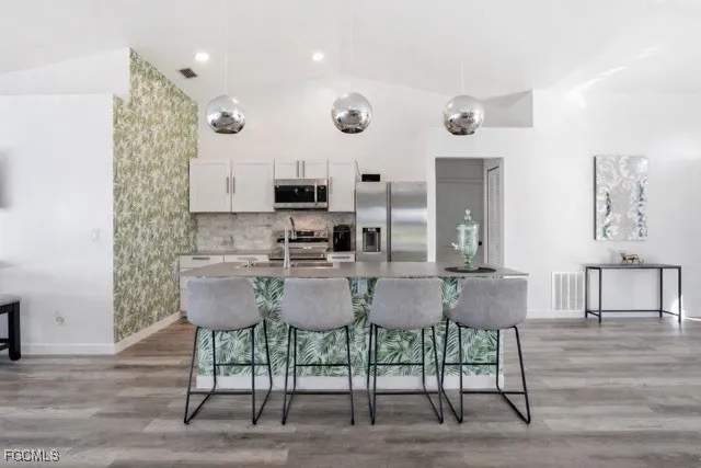 a kitchen with stainless steel appliances a stove microwave and sink