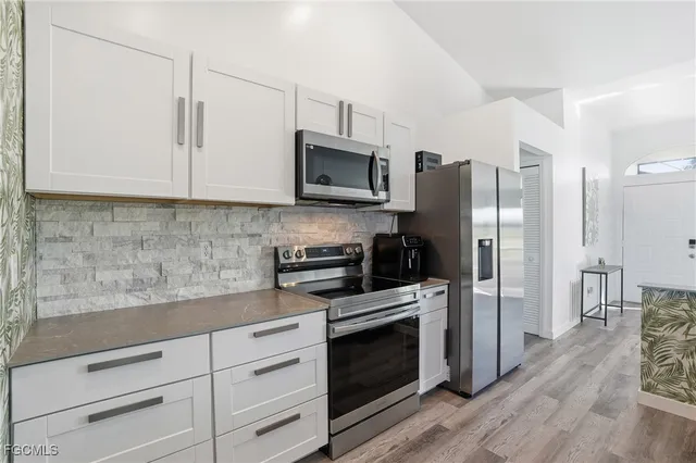 a kitchen with a sink stove and wooden floor