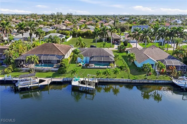 an aerial view of residential houses with outdoor space and trees
