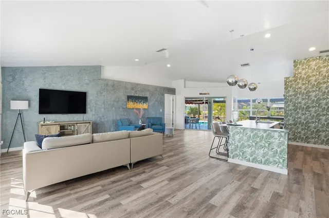 a kitchen with stainless steel appliances a dining table chairs stove and cabinets