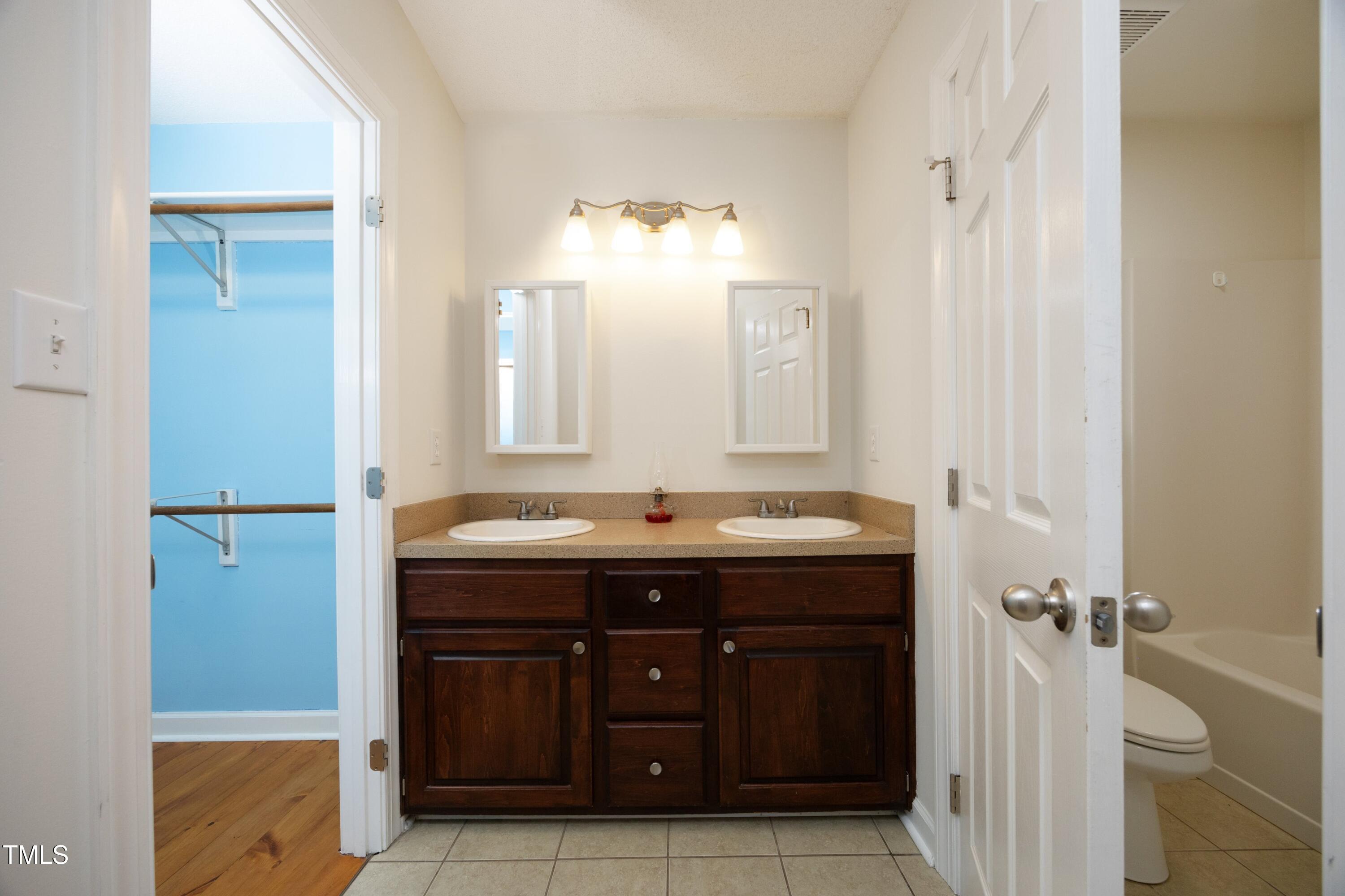 101 Ryans Run Youngsville, NC 27596 - Photo 17 of 33 a bathroom with a granite countertop sink a toilet and a mirror