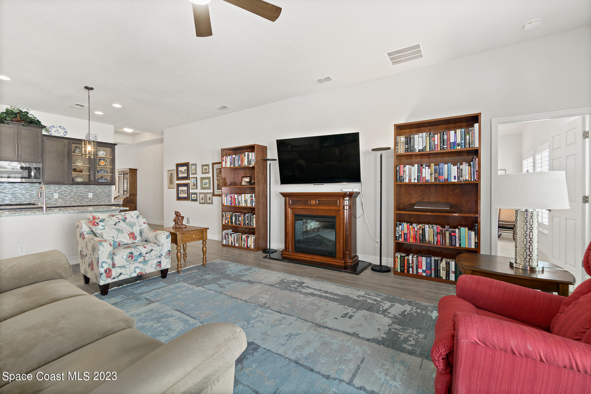 4302 Ruthann Circle Melbourne, FL 32934 - Photo 14 of 45 a living room with furniture a flat screen tv and a fireplace