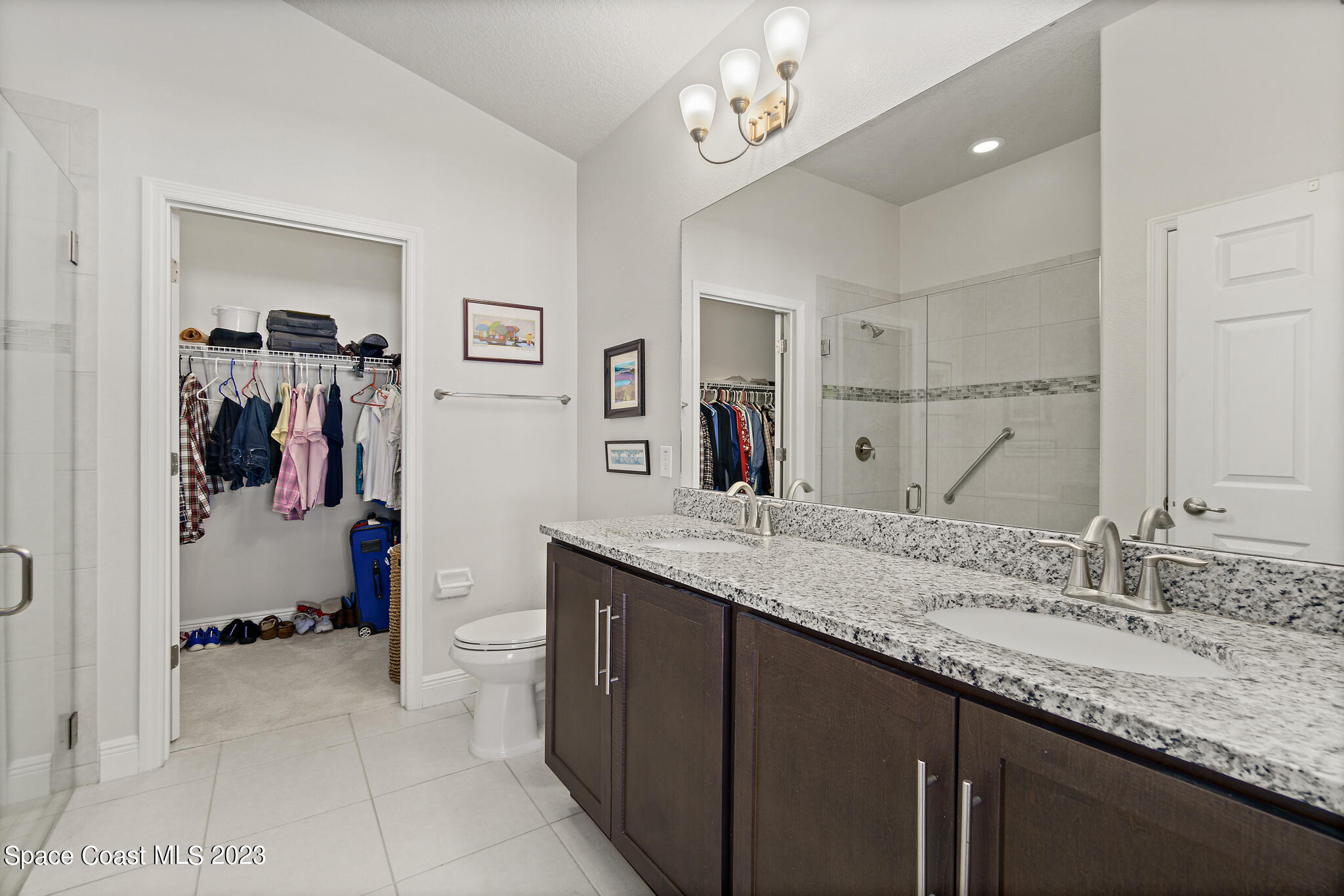 4302 Ruthann Circle Melbourne, FL 32934 - Photo 27 of 45 a spacious bathroom with a granite countertop sink a mirror and a shower