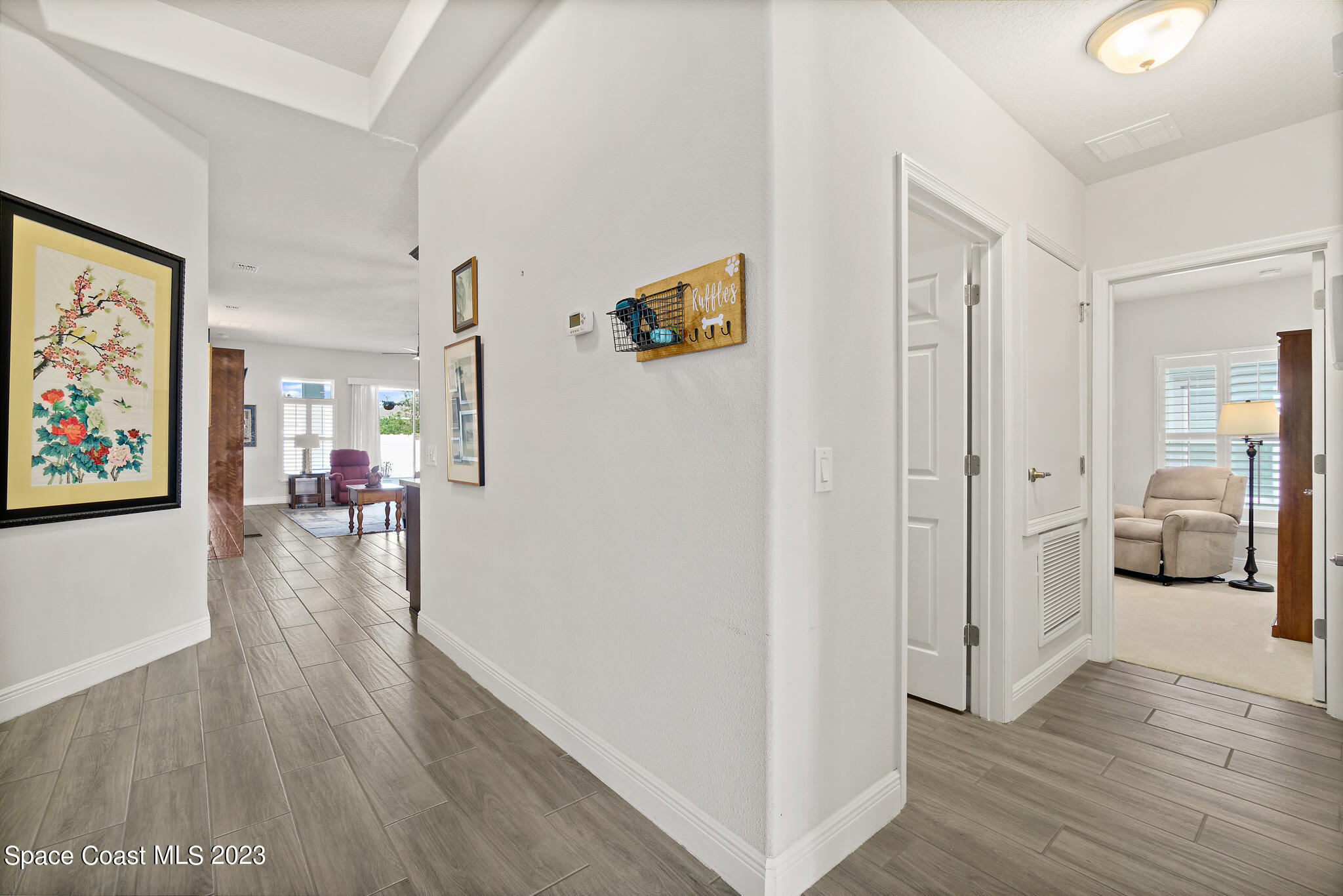 4302 Ruthann Circle Melbourne, FL 32934 - Photo 5 of 45 a hallway with wooden floor and furniture