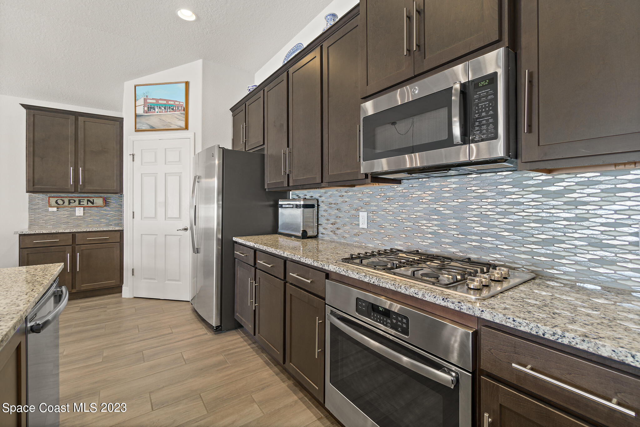 4302 Ruthann Circle Melbourne, FL 32934 - Photo 10 of 45 a kitchen with stainless steel appliances granite countertop a stove microwave and refrigerator