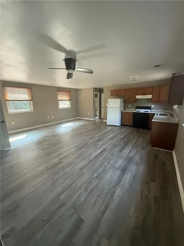 a view of a living room a stove and kitchen