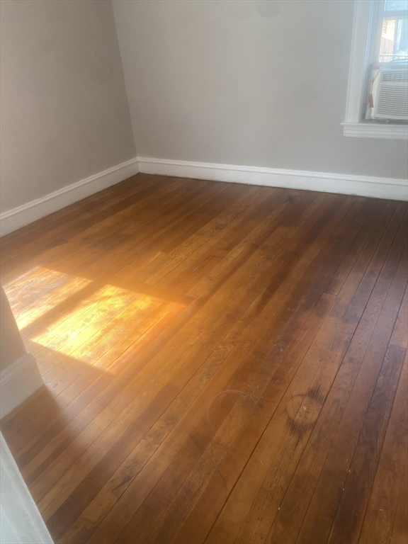 583 Center Street, Unit 2 Fall River, MA 02724 - Photo 5 of 6 a view of an empty room with wooden floor and a window