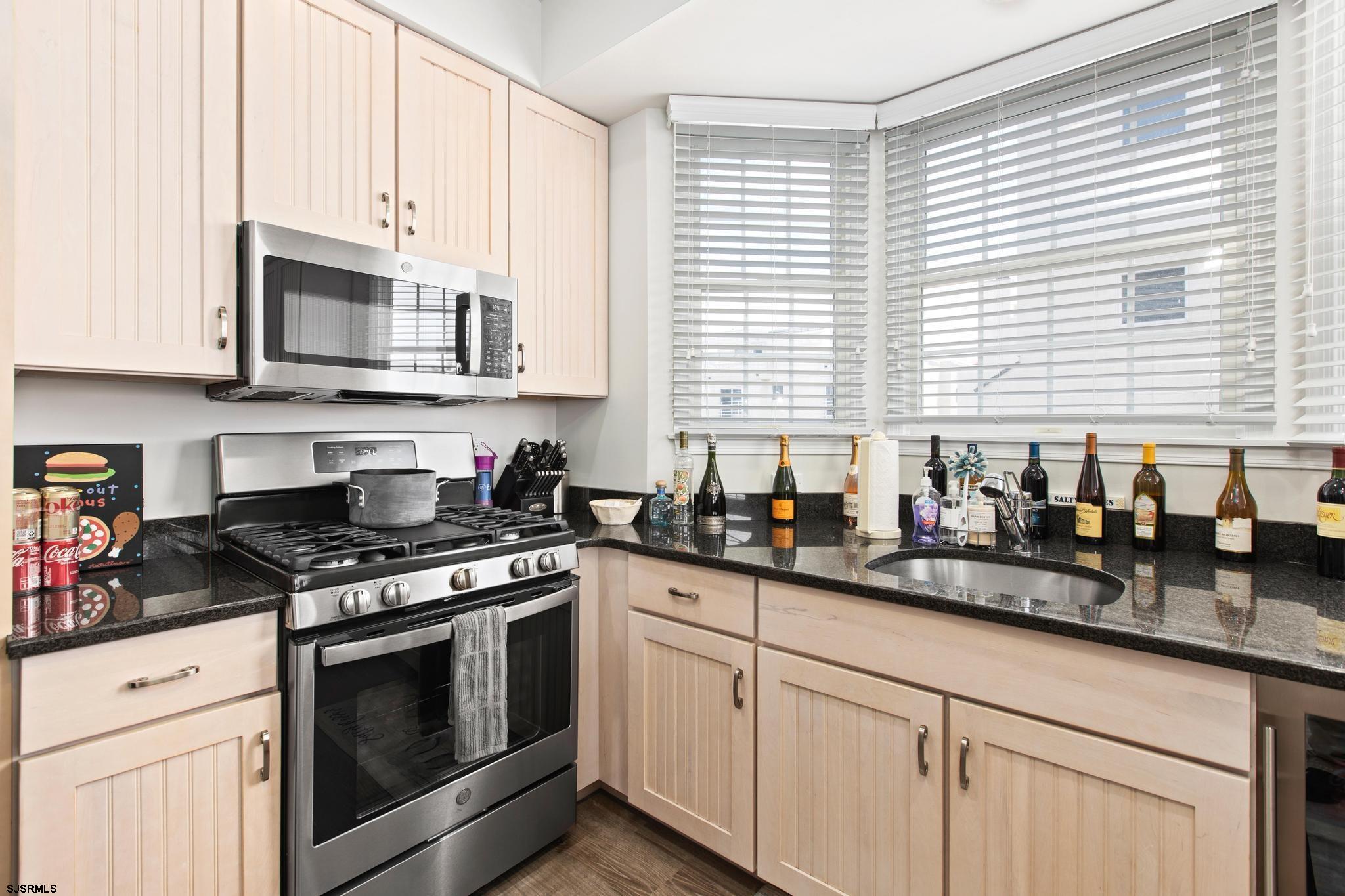 1 South Douglas Avenue, Unit 1 Margate City, NJ 08402 - Photo 21 of 48 a kitchen with stainless steel appliances granite countertop white cabinets and a stove top oven