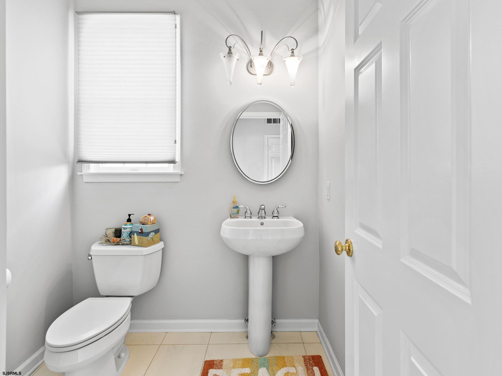 1 South Douglas Avenue, Unit 1 Margate City, NJ 08402 - Photo 25 of 48 a bathroom with a sink mirror toilet and a shower