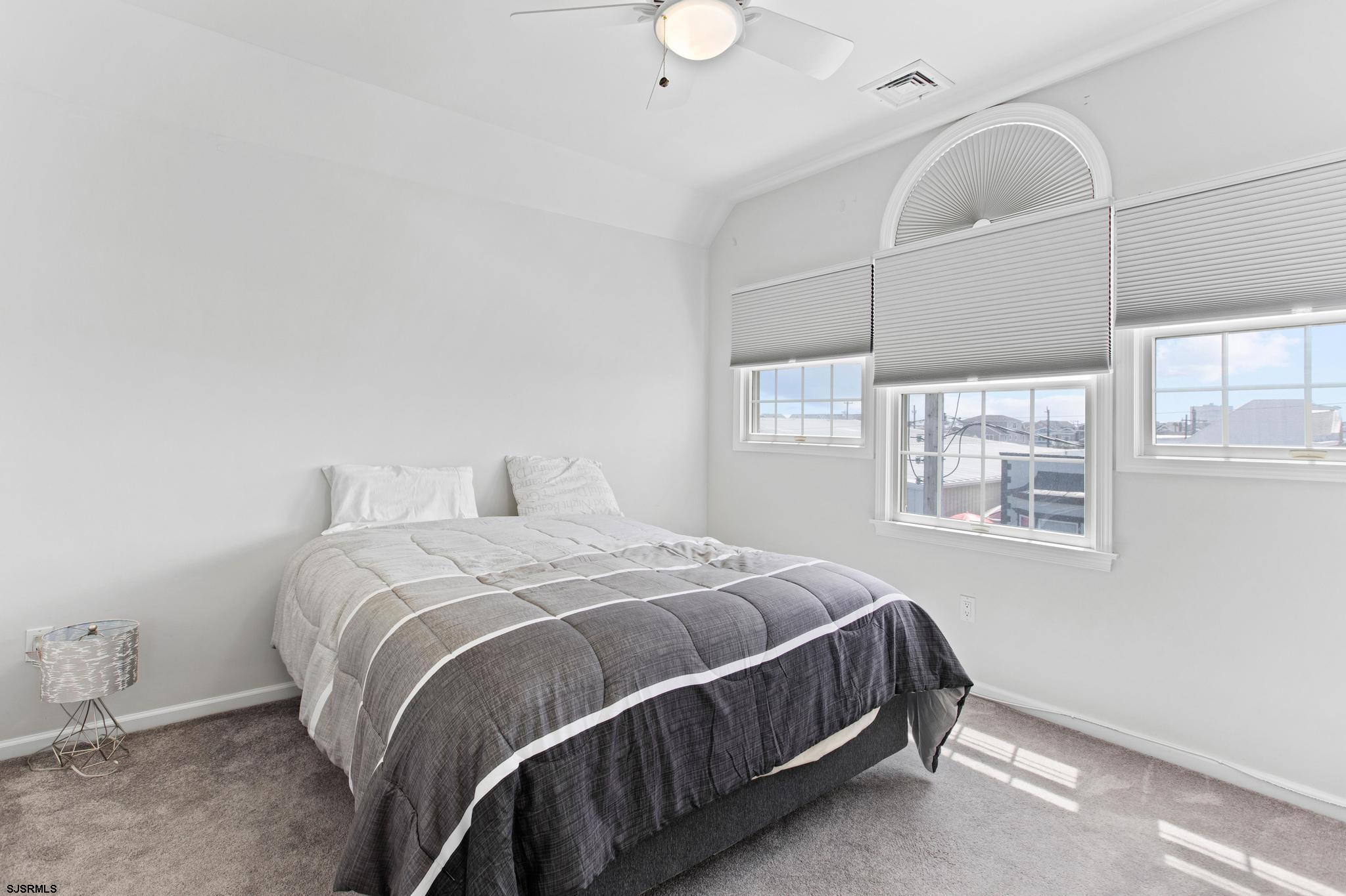 1 South Douglas Avenue, Unit 1 Margate City, NJ 08402 - Photo 32 of 48 a bed sitting in a bedroom next to a window