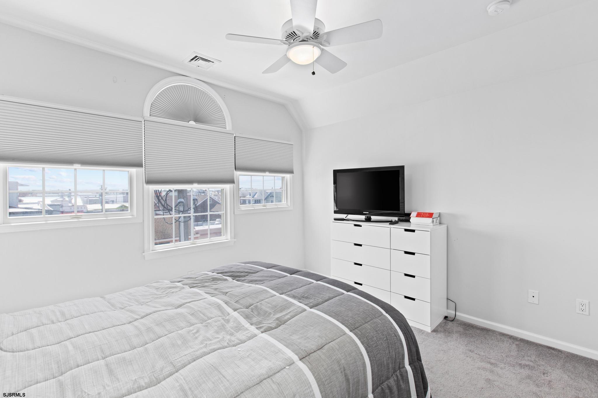 1 South Douglas Avenue, Unit 1 Margate City, NJ 08402 - Photo 33 of 48 a bedroom with a bed tv and a window