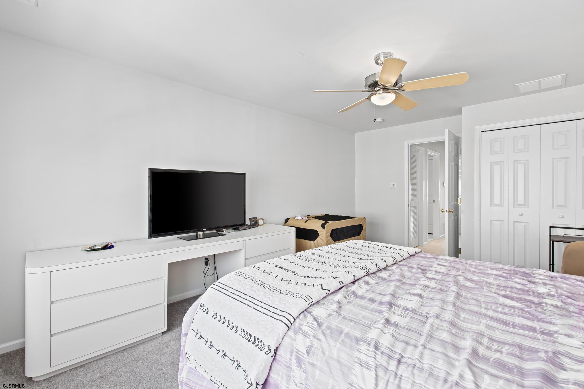 1 South Douglas Avenue, Unit 1 Margate City, NJ 08402 - Photo 36 of 48 a bedroom with a bed and a flat screen tv