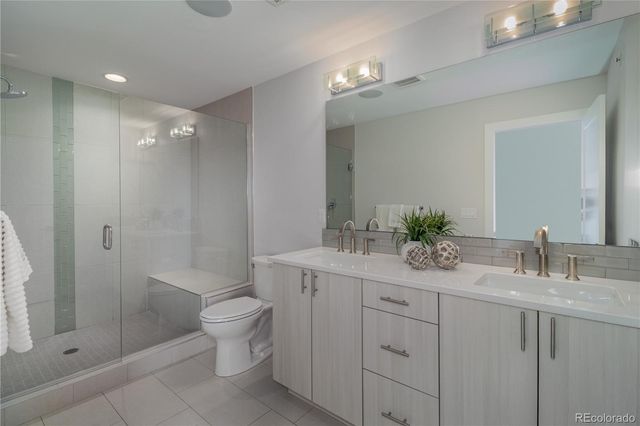 a bathroom with a granite countertop sink a toilet and shower
