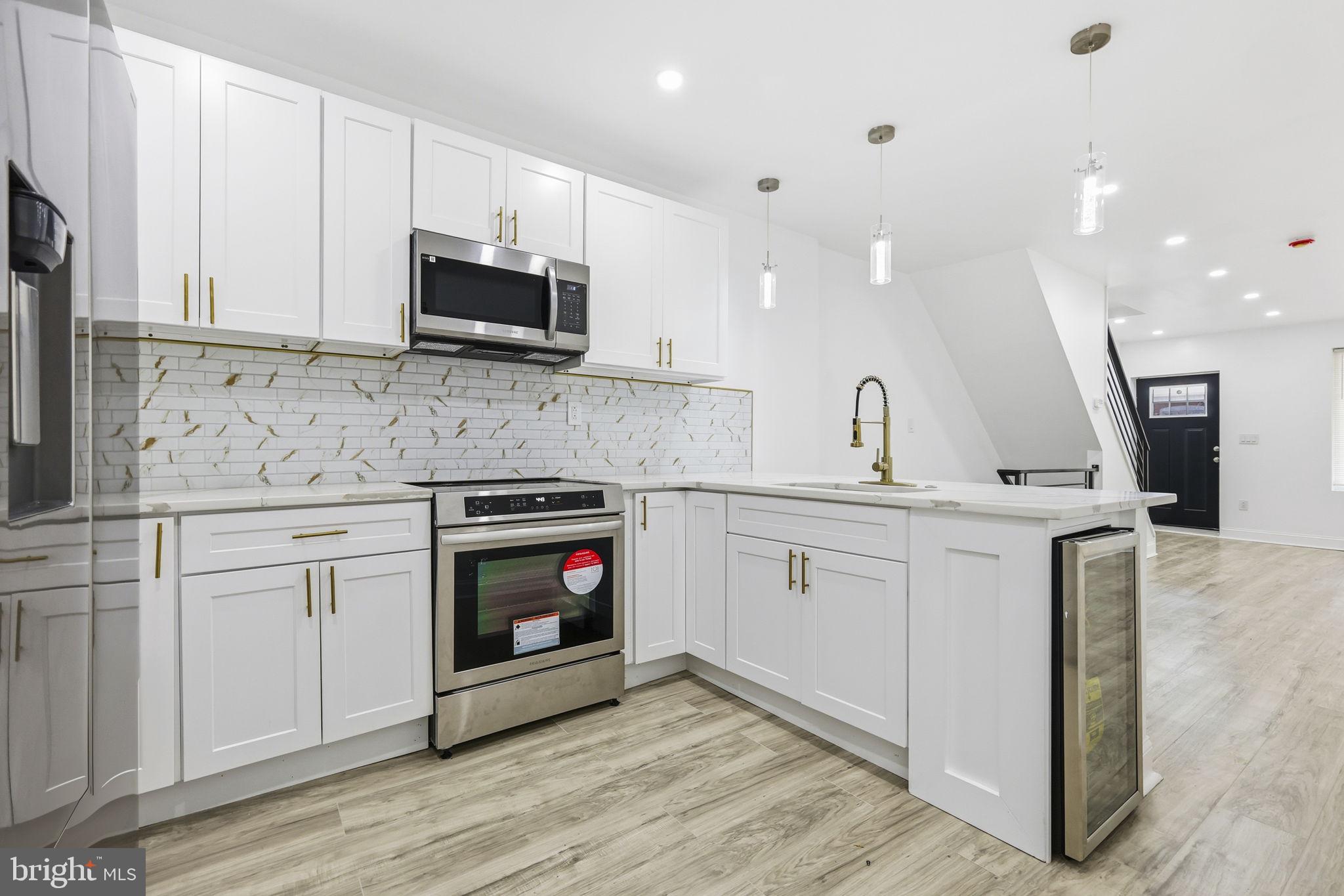5542 Pemberton Street Philadelphia, PA 19143 - Photo 3 of 22 a kitchen with stainless steel appliances granite countertop a stove and a sink