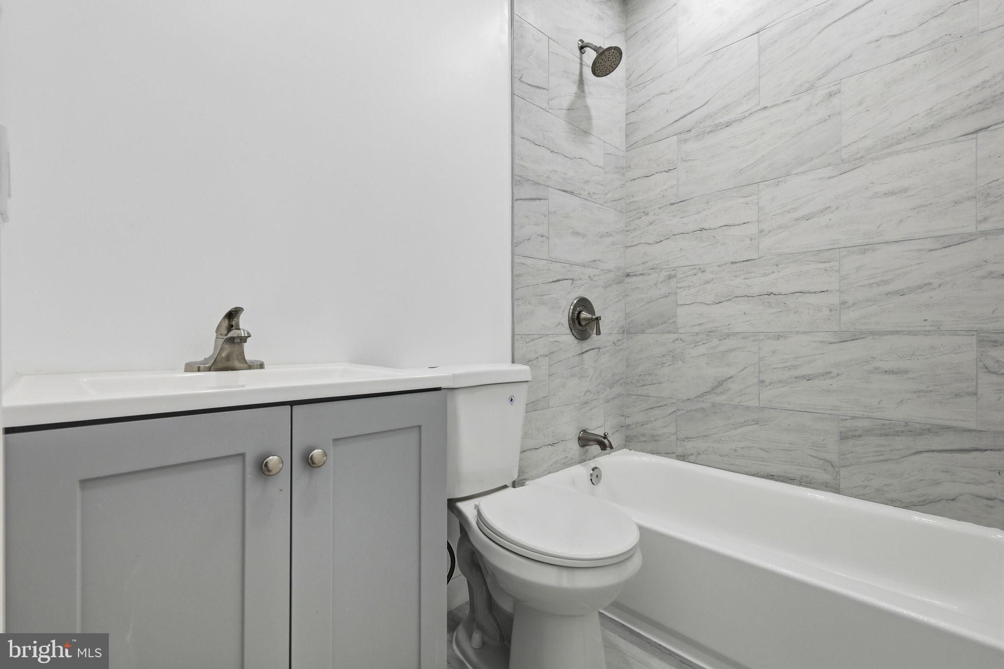 5542 Pemberton Street Philadelphia, PA 19143 - Photo 9 of 22 a bathroom with a sink a toilet and bathtub