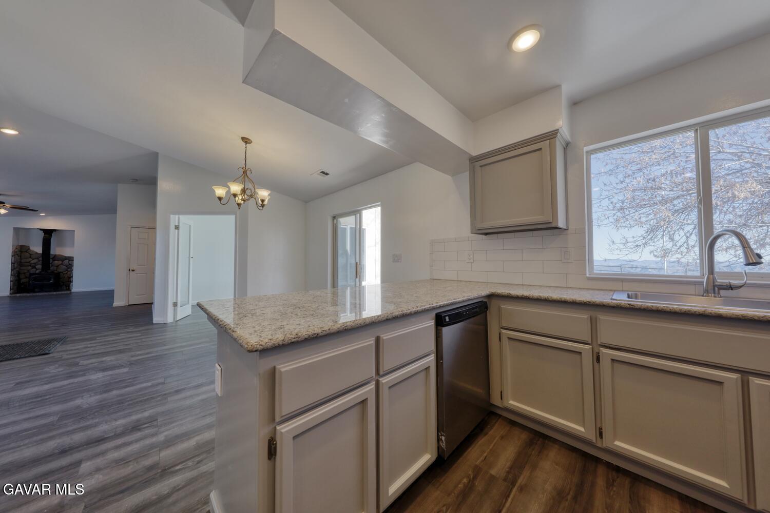 26801 Cabriolet Court Tehachapi, CA 93561 - Photo 15 of 60 a kitchen with granite countertop cabinets stainless steel appliances a sink and a large window