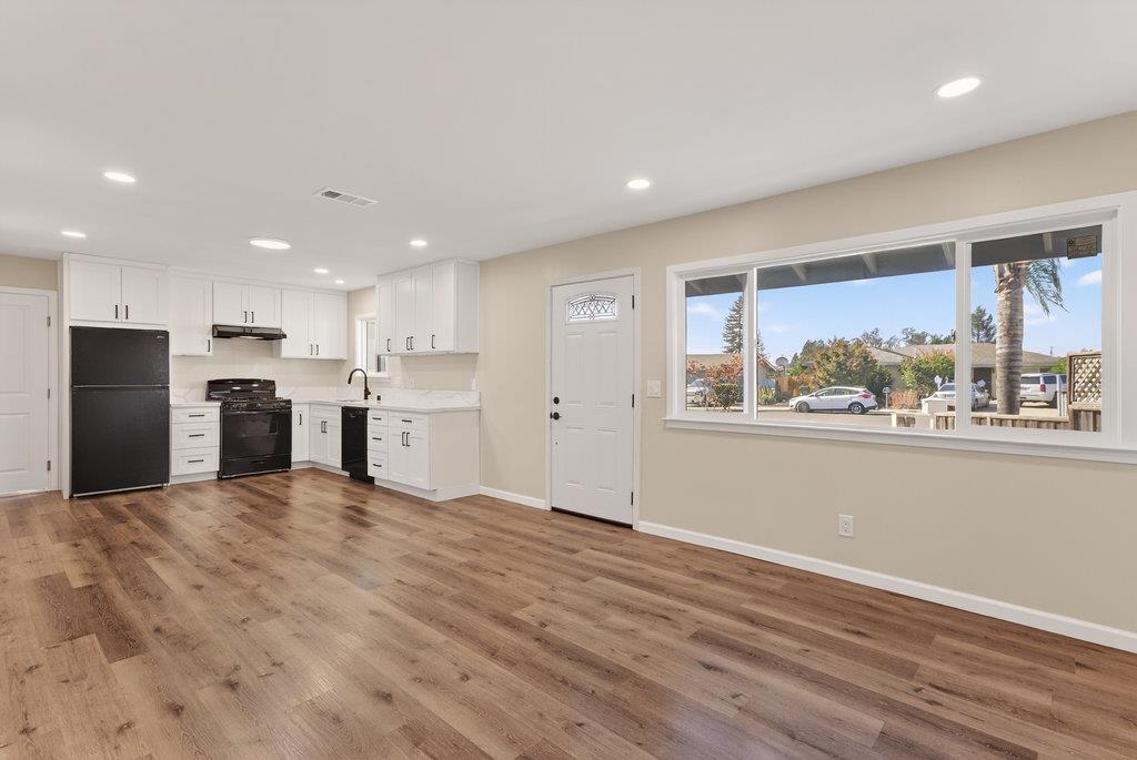 136 Lester Court Watsonville, CA 95076 - Photo 25 of 32 a view of an empty room with kitchen view and wooden floor