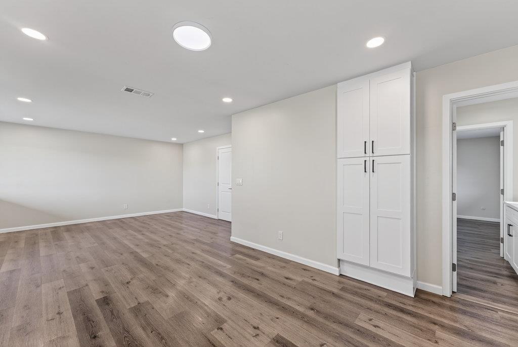 136 Lester Court Watsonville, CA 95076 - Photo 8 of 32 an empty room with wooden floor and windows
