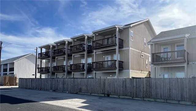 a view of a house with wooden fence