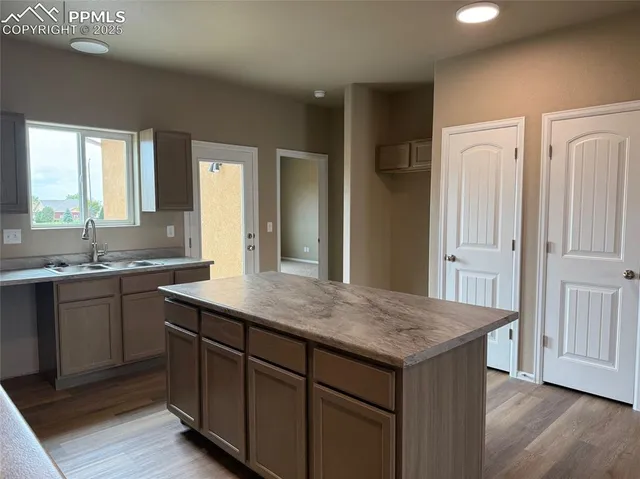 a kitchen with a sink dishwasher and wooden cabinets