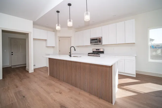 a kitchen with kitchen island a sink stainless steel appliances and cabinets