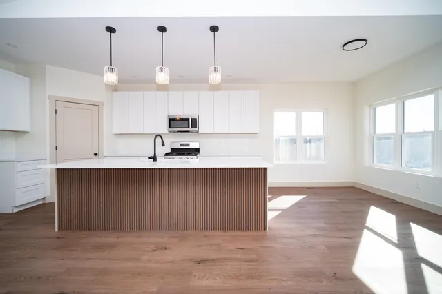 a kitchen with kitchen island a sink stainless steel appliances and cabinets