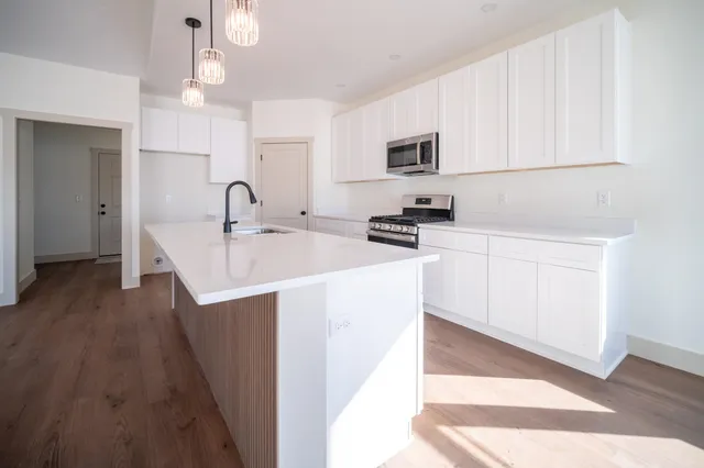 a kitchen with stainless steel appliances a sink a stove a microwave a sink a refrigerator and cabinets