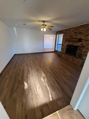 a living room with hard wood floors and a fireplace