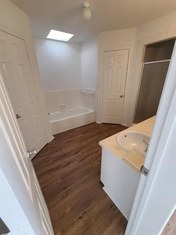 a bathroom with a tub sink and a mirror