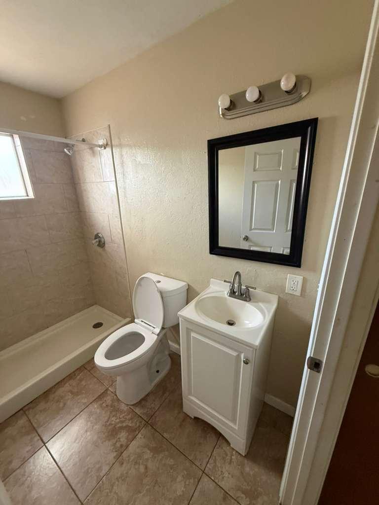 1955 East 8th Street, Unit 1 Douglas, AZ 85607 - Photo 13 of 16 a bathroom with a toilet sink and mirror
