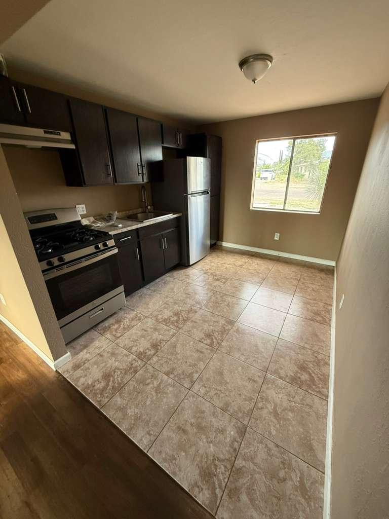 1955 East 8th Street, Unit 1 Douglas, AZ 85607 - Photo 4 of 16 a kitchen with granite countertop a stove and a refrigerator