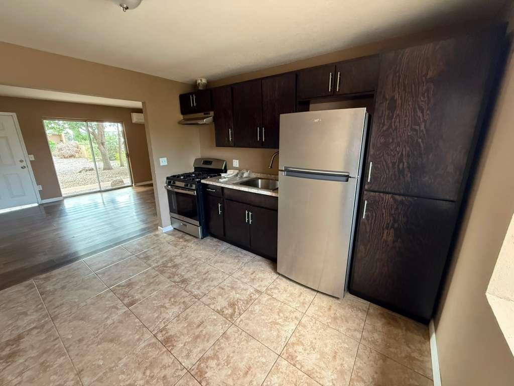 1955 East 8th Street, Unit 1 Douglas, AZ 85607 - Photo 6 of 16 a kitchen with granite countertop a refrigerator a stove a sink a washer and dryer