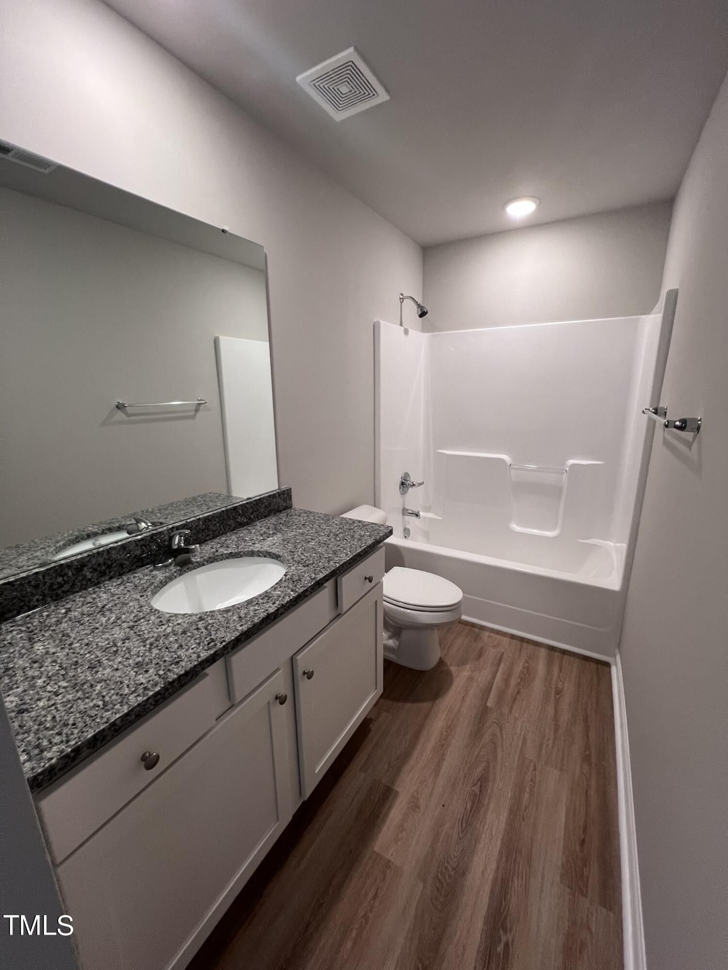 339 Bushel Lane Willow Spring, NC 27592 - Photo 14 of 18 a bathroom with a granite countertop double vanity sink a mirror and a bathtub